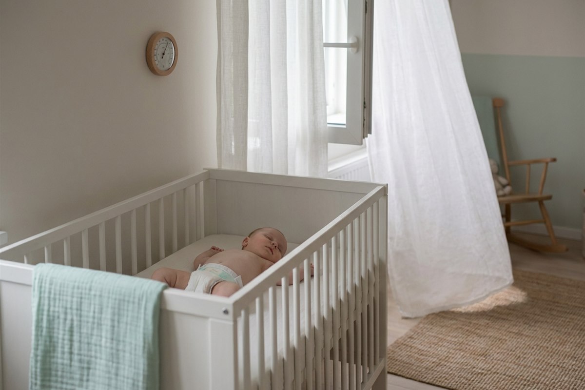 Bebis sover svalt pa rygg i endast bloja under varmebolja