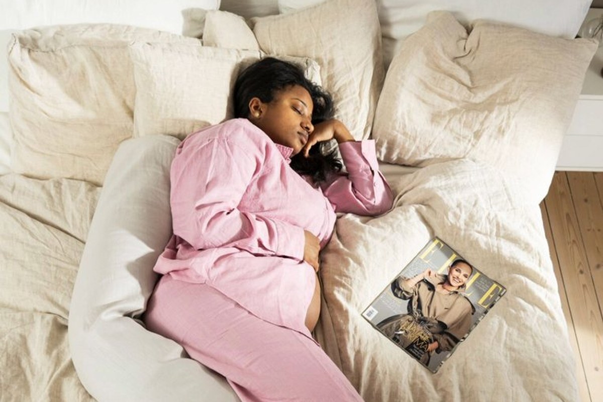 Gravid kvinna sover på sidan med Najell gravidkudde